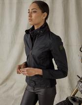 A woman is standing next to a motorcycle in a Belstaff Antrim Women's Jacket.
