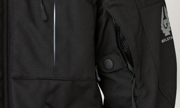 A close up of a Belstaff Highway Jacket with a logo on it.